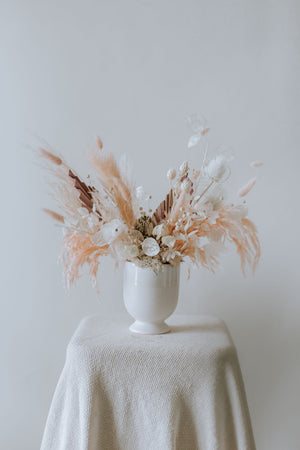 Small Everlasting Arrangement in Soft Glow - Warm-hued dried blossoms exuding a gentle luminescence in a doll white porcelain vase
