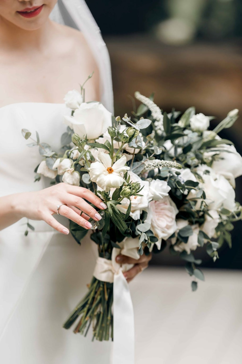 Close-up view of Forest Wonderland bridal bouquet featuring a mix of green foliage and vibrant flowers, elegantly tied together.